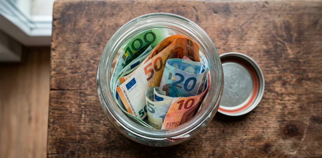 Pot de billets qui image la requête "combien avoir de côté" pour faire référence à l'épargne à détenir à 30, 40 ou 50 ans